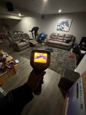 thermal imaging camera scanning a finished basement family room for hidden moisture, Woodbridge VA
