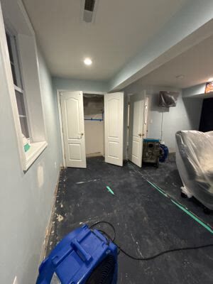 air movers drying a basement room with carpet removed and furniture wrapped in plastic, Woodbridge VA