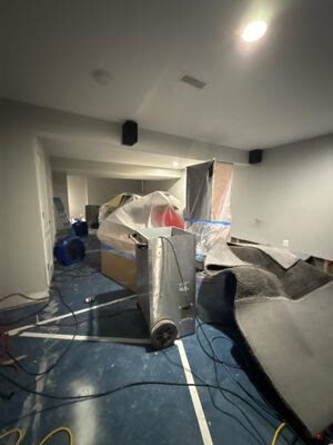 dehumidifier in a basement with carpet rolled back and contents covered in plastic, Woodbridge VA