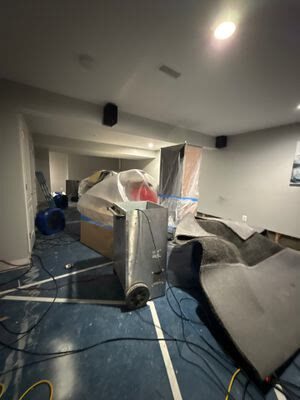 drying equipment positioned among rolled-back carpet and plastic-covered furniture in a basement, Woodbridge VA