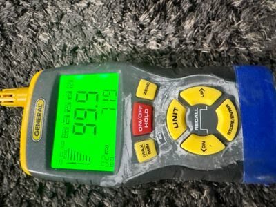 handheld thermo-hygrometer displaying temperature and humidity readings during drying monitoring, Woodbridge VA