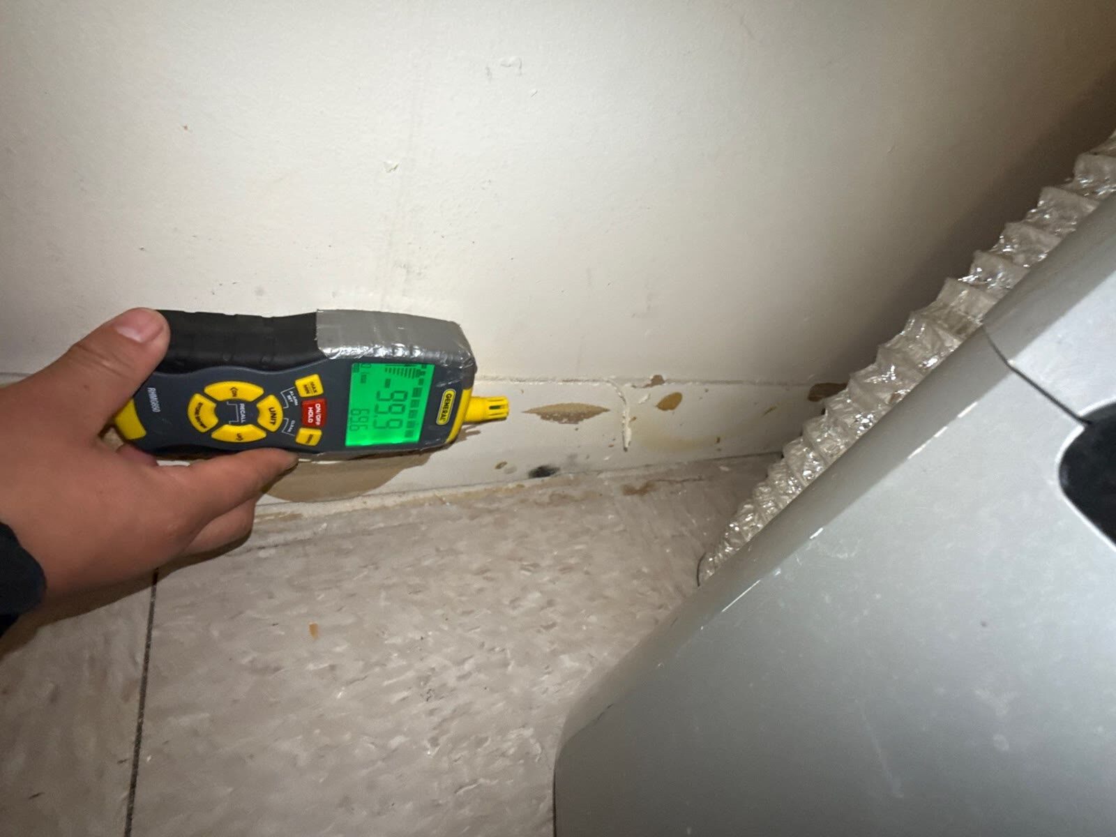 moisture meter reading heavy saturation at the wall base, Arlington VA