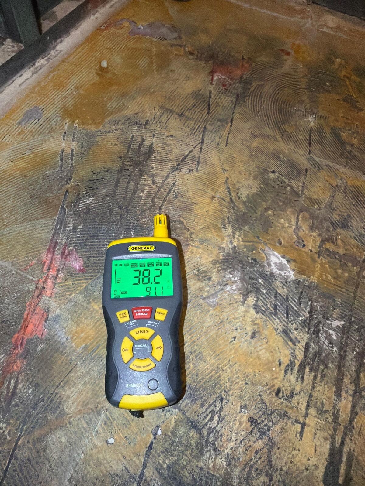 moisture meter verifying progress on the drying subfloor, Arlington VA
